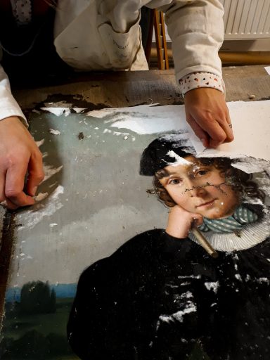 la restauratrice de tableau retire un cartonnage. Cette opération de cartonnage était nécessaire avant de rentoiler le tableau. 